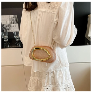Champagne gold evening bag with sparkling sequins and large oval metal handle worn on shoulder