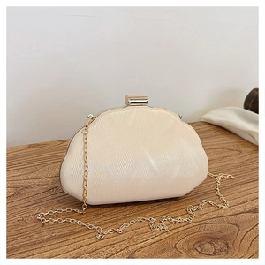 Detail of pleated texture and gold round lock on beige satin evening clutch bag