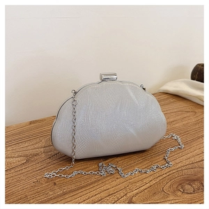 Close-up of silver evening clutch bag featuring 3D wavy texture and metal chain strap