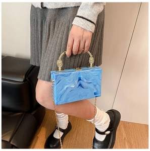 Detail of blue marble acrylic clutch bag with vintage gold handle and chain strap
