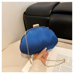 Detail of electric blue evening clutch bag with wavy texture and gold chain strap
