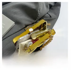 Detailed internal view of golden acrylic marble evening bag with beaded metal handle