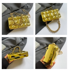 Detail view of gold textured evening clutch with beaded handle and metal chain strap