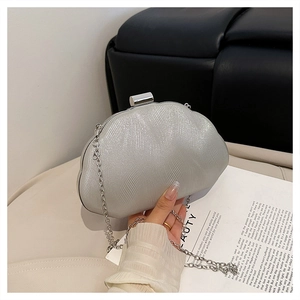 Close-up of silver shell-shaped evening clutch with wavy texture and chain strap