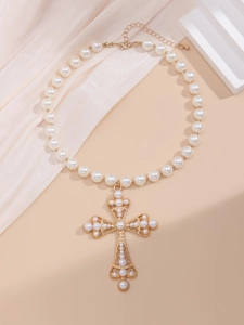 Detailed macro view of vintage gold cross pendant with pearls on a necklace