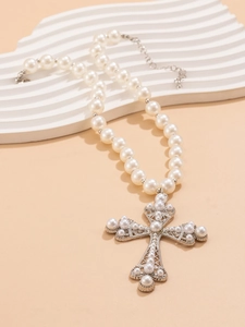 Detail of silver hollow cross pendant with pearls on a multi-layer necklace