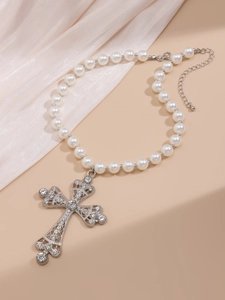 Close-up of pearl necklace featuring a large crystal-encrusted hollow cross pendant