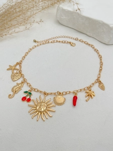 Dettaglio della collana dorata a tema marino con ciondoli a stella marina, conchiglia e cuore