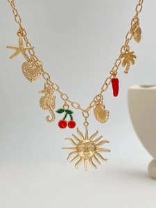 Dettaglio della collana dorata a tema oceano con ciondoli a stella marina e conchiglia