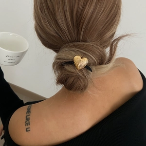 Élastique à cheveux chic avec cœur doré texturé sur une coiffure en chignon élégant