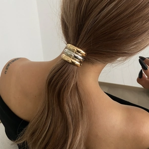 Élastique à cheveux minimaliste en métal doré et argenté sur une queue de cheval