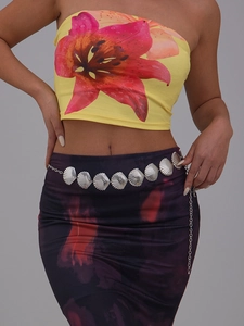 Detail view of a stylish silver shell-themed waist chain accessory on a model's waist.