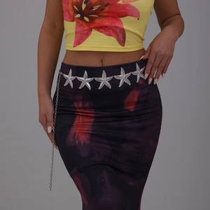Close-up of a silver oversized starfish waist chain accessory on a floral dress