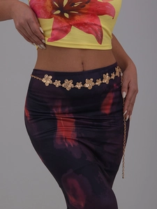 Detail of golden metal waist chain featuring textured 3D flower charms for women
