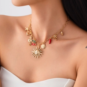 Collana dorata stile oceano con ciondoli a stella marina e conchiglia su una modella