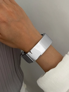 Gros plan sur le bracelet manchette argenté poli avec finition miroir brillante minimaliste