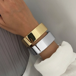 Bracelet jonc ouvert large en métal poli doré et argenté au design minimaliste chic