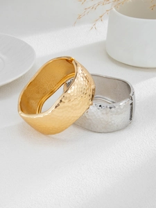 Detail of wide hammered texture cuff bracelets in gold and silver finish with side opening