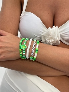 Details von fünf bunten Heishi-Armbändern mit SPRING-Schriftzug am Handgelenk