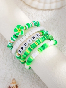 Detail bunter Polymer-Ton-Armbänder mit Schriftzug 'SPRING' und einem Blumenanhänger