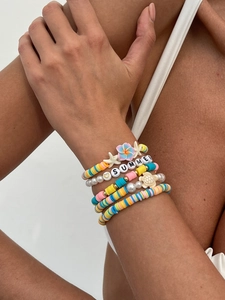 Detailaufnahme mehrlagiger Sommer-Armbänder mit bunten Perlen und Anhängern