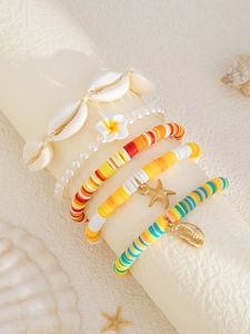 Detailansicht bunter Boho-Armbänder mit Muscheln und Seesternen auf einem Display