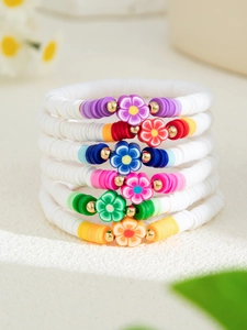 Detailansicht der sechs bunten Polymer-Ton-Blumenarmbänder mit weißen Perlen und Goldakzenten