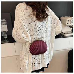 Detailed back view of a dark red shell-shaped evening clutch with gold chain strap