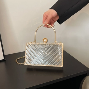 Detail der klaren Acryl-Abendtasche mit V-Muster und goldenem metallischem Griff