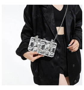Silver metallic pleated handbag with unique bead handle and chain strap on model