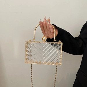Detail der transparenten Acryl-Clutch mit Goldrahmen, Streifen und Perlenverschluss