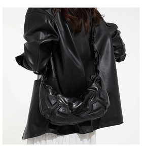 Dettaglio borsa a spalla in pelle nera geometrica con trama a rilievo in stile futuristico