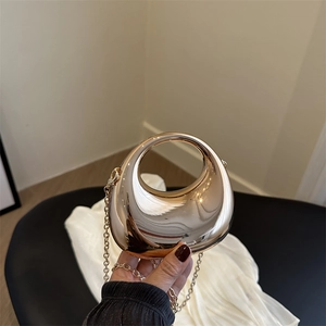Golden crescent evening clutch bag with metallic mirror finish and chain strap