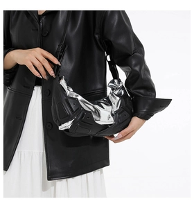 Dettaglio della borsa techwear futuristica con guscio nero e fodera metallica argentata