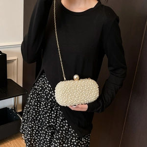 Detail of luxury pearl evening clutch with gold chain strap and ornate pearl clasp