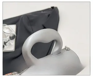 Vue détaillée du sac cylindrique givré argenté avec poignée épaisse et chaîne en métal