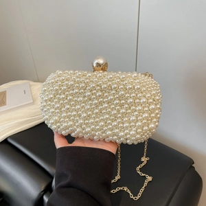 Detail of handmade ivory pearl evening clutch with gold hardware and chain strap
