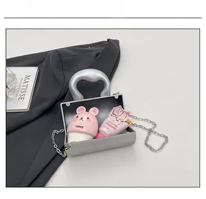 Détail de la capacité du mini sac argenté montrant l'espace pour cosmétiques et accessoires