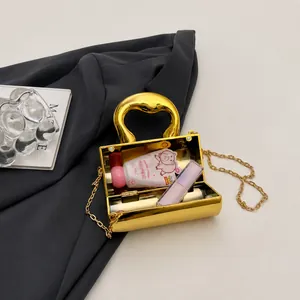Macro view showing the capacity of a gold metallic mini evening bag with chain strap