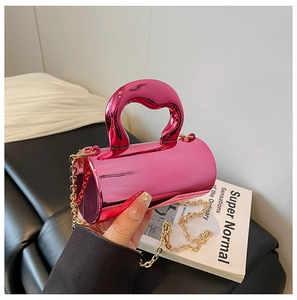 Macro detail of pink metallic mini cylinder handbag with elegant gold chain strap