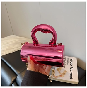 Close-up of a magenta metallic cylindrical handbag with a gold chain strap
