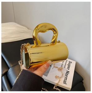 Close-up of elegant gold cylinder handbag with mirror finish and thick top handle