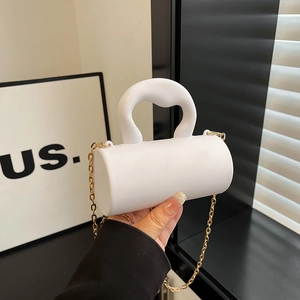 White cylinder acrylic evening bag with gold chain and sculptural top handle