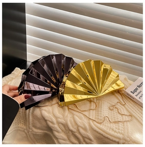 Close-up of fan-shaped acrylic evening clutches in gold and purple with metal chains