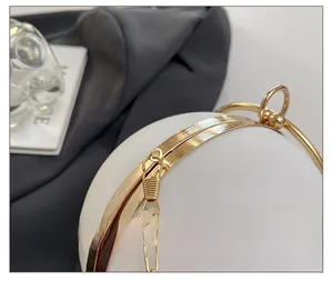 Detail showing high-quality gold hardware and hook on white spherical evening clutch bag