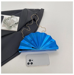 Detailed view of blue fan-shaped evening clutch with gold chain and glossy metallic finish