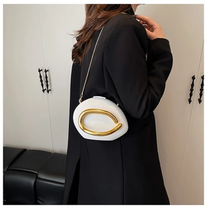 Detailed side view of a white pebble acrylic box bag with chunky gold metal ring decor