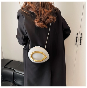 Rear view of a white acrylic box bag with a large gold ring detail and chain strap