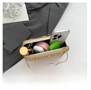 Detail showing gold chain bag interior with phone and cosmetics on Matisse magazine