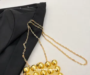 Detailed macro view of the refined gold chain strap and spherical metal accents